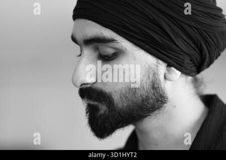 Cremona, Italien - 21. Juli 2025 Nahaufnahme eines bärtigen Mannes, der einen Turban mit geschlossenen Augen trägt, in Nachsicht und Reflexion mit einem Gedanken provoki Stockfoto