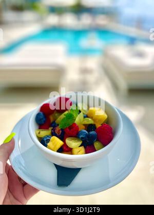Frischer tropischer Obstsalat, der an einem sonnigen Sommertag auf den Cayman Islands in einem luxuriösen Resort-Pool serviert wird. Stockfoto