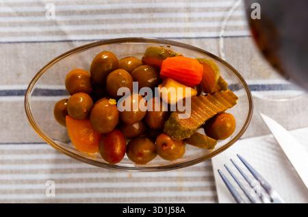 Grüne Oliven serviert mit Gurke, Karotte, Knoblauch und Zwiebeln Stockfoto