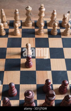 Holzschachsteine starten das Spiel auf einem klassischen Schachbrett Stockfoto