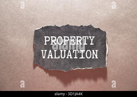 Text zur Bewertung des Hotels auf Notizblock mit Hausmodell und Schlüssel auf Holzschreibtisch Stockfoto