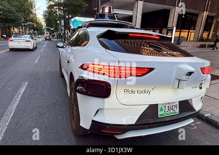 Atlanta, Usa. Oktober 2025. Ein selbstfahrendes Waymo-Fahrzeug fährt am 22. Oktober 2025 durch die Straßen der Innenstadt von Atlanta, Georgia. Waymo, das Unternehmen der Alphabet Inc., betreibt vollelektrische, vollständig selbstfahrende Taxis für die öffentliche Nutzung in mehreren US-Städten, darunter Atlanta, Phoenix, San Francisco und Los Angeles. (Foto: Samuel Rigelhaupt/SIPA USA) Credit: SIPA USA/Alamy Live News Stockfoto