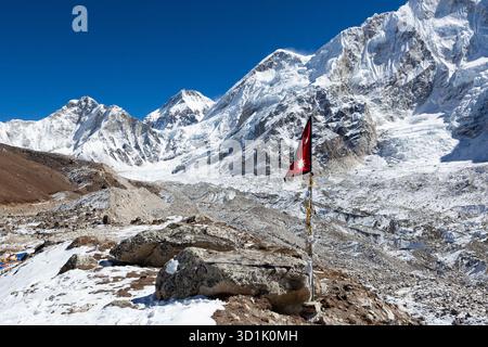 Flagge von Nepal auf dem Everest Base Camp Trek. Himalaya-Landschaft mit Khumbu-Gletscher und hohen schneebedeckten Berggipfeln. Stockfoto