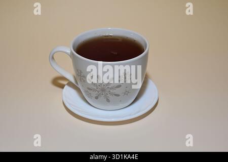 Weiße Tasse schwarzen Tee mit Schneeflocken Stockfoto