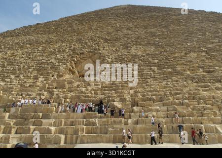 Touristen erkunden und klettern die große Pyramide von Gizeh an einem sonnigen Tag in Ägypten Stockfoto