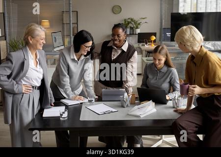 Verschiedene Gruppen von Frauen mittleren Alters und jungen Erwachsenen, die gemeinsam Brainstorming machen Stockfoto
