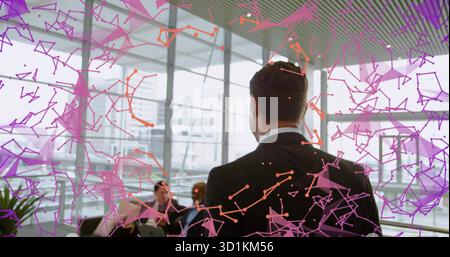 Asiatischer Mann im Anzug, der das Wachstum in der Bürolounge erklärt, mit Laptop und Netzwerkgrafik Stockfoto