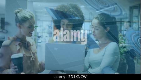 Drei Frauen in lässiger Kleidung, die im Coworking Office zusammenarbeiten, mit Laptop-Plan Stockfoto