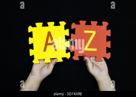 Hände, die die Buchstaben A und Z halten, symbolisieren den gesamten Alphabetbereich Stockfoto
