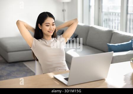 Frau, die sich nach der Arbeit am Laptop im Homeoffice entspannt Stockfoto