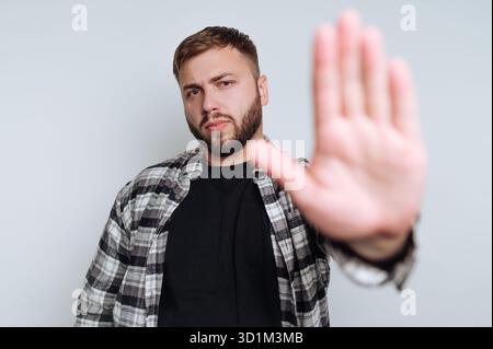Mann in lässiger Kleidung, der mit der Hand eine Stop-Geste macht. Stockfoto