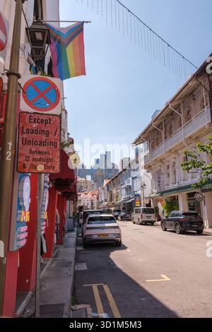 Eine lebhafte Straße in Chinatown bietet farbenfrohe traditionelle Gebäude, moderne Wolkenkratzer und geschäftige Fahrzeuge. Stockfoto