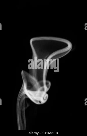 Nahaufnahme von weißem Wasserdampf mit Spray aus dem Luftbefeuchter. Isoliert auf schwarzem Hintergrund. Dampfrauch auf schwarzem Hintergrund. Weißer Fantasy-Rauch Stockfoto