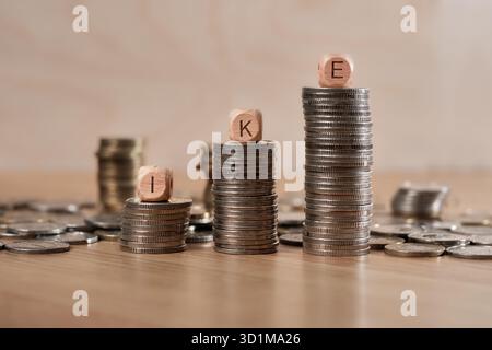 Holzwürfel mit den Buchstaben IKE (individuelles Alterskonto â€“ Indywidualne Konto Emerytalne) auf Stapeln polnischer Münzen als Symbol für Spareinlagen und Finanzwachstum. Stockfoto