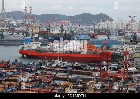 BUSAN, SÜDKOREA - 9. OKTOBER 2025 - Übersicht über den Hafen von Busan mit vielen Schiffen, stark frequentierten Werften und Industriekränen Stockfoto
