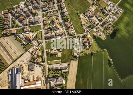 Fesselnde Luftperspektive auf ein malerisches Dorf inmitten der üppigen, grünen Felder im Po-Tal in Italien Stockfoto