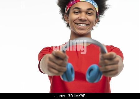 Freizeit. Dunkelhäutiger junger Mann mit Kopfhörern, die zufrieden aussehen Stockfoto