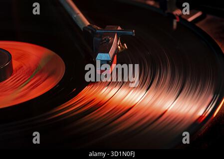 Nadeldetails auf Vinyl-Schallplatte auf Plattenspieler, Bild bei schwachem Licht mit Reflexion Stockfoto