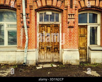 Geschlossene Holztür des Eingangs zum alten Ziegelgebäude Stockfoto