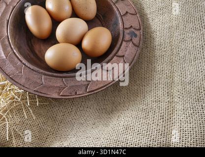 Sechs Eier aus lackiertem Kupfer Platte auf einem braunen Sack (Leinwand) - traditionelle Organic Food Konzept Demonstration Stockfoto