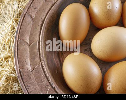 Eier aus lackiertem Kupfer Platte auf einem braunen Sack (Leinwand) - traditionelle Organic Food Konzept Demonstration Stockfoto