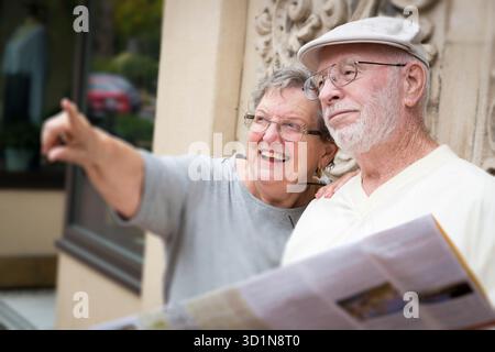 Senior-Touristenpaar mit Blick auf Brochure Map Stockfoto