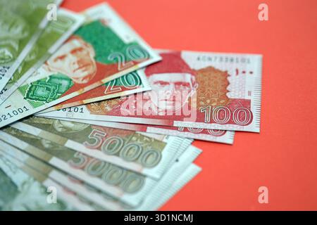 Pakistanische Rupien Banknoten auf rotem Hintergrund. Die aktuellen pakistanischen Geldrechnungen liegen in großer Höhe auf dem Tisch. Das Konzept des Geschäfts und der Investitionen in Pakistan Stockfoto