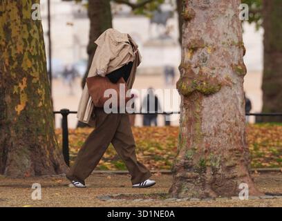 Leute, die im Regen auf der Mall in London laufen. Bilddatum: Mittwoch, 29. Oktober 2025. Stockfoto