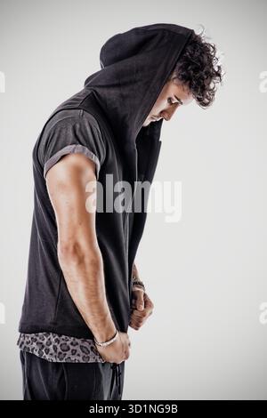 Profil eines harten jungen Mannes in dunklem T-Shirt Stockfoto