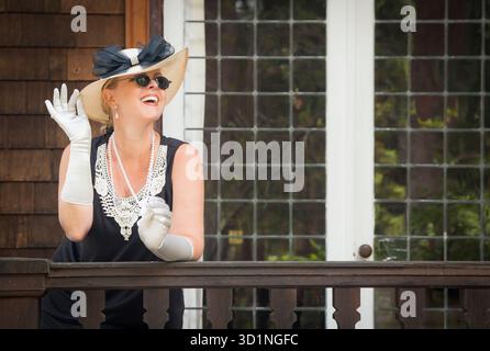 Attraktive Frau im Zwanziger-Outfit auf der Veranda des Antiquitätenhauses Stockfoto