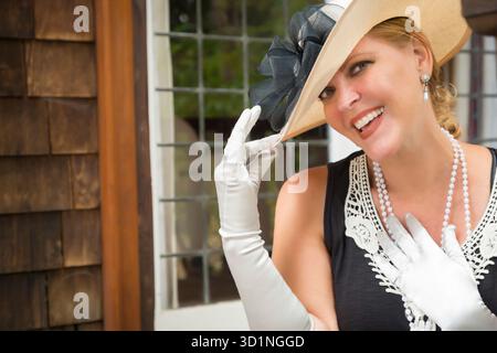 Attraktive Frau im Zwanziger-Outfit auf der Veranda des Antiquitätenhauses Stockfoto
