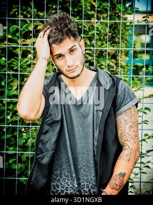 Harter junger Mann in dunklem T-Shirt draußen Stockfoto