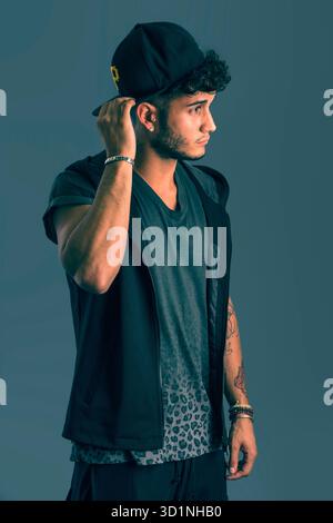 Harter junger Mann in dunklem T-Shirt auf grauem Hintergrund Stockfoto