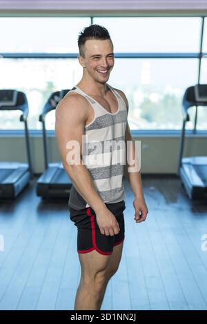 Porträt eines durchtrainierten jungen Mannes im modernen Fitness-Center Stockfoto