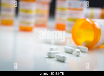 Arzneimittelflaschen Hinter Pillen, Die Aus Der Gefallenen Flasche Verschüttet Werden Stockfoto