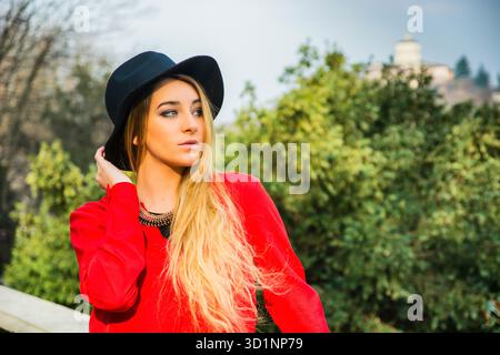 Schöne junge Frau in rotem Kleid, draußen Stockfoto