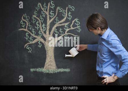 Gießkanne und Geldbaum gezeichnet auf einer Tafel-Konzept für Investitionen, Einsparungen und machen Geld Stockfoto