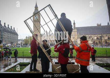 London, Großbritannien. Oktober 2025. Aktivisten von Greenpeace UK installieren am 29. Oktober 2025 Gefängniskäfige um Statuen von Nelson Mandela, Mahatma Gandhi und Millicent Fawcett auf dem Parliament Square in London, England. Der Protest unterstreicht das scharfe Vorgehen der britischen Regierung gegen das Recht auf Protest gemäß der jüngsten Gesetzgebung, von der Aktivisten sagen, dass es bürgerliche Freiheiten und friedliche Dissens bedroht. (Foto: Pete Speller/SIPA USA) Credit: SIPA USA/Alamy Live News Stockfoto