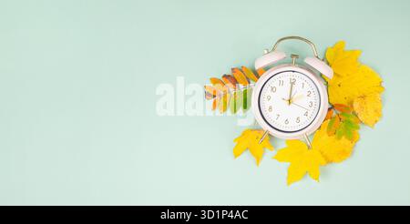 Winterumstellung, Ende der Sommerzeit im Herbst, Wecker-Rückfallschalter, buntes Laub Stockfoto