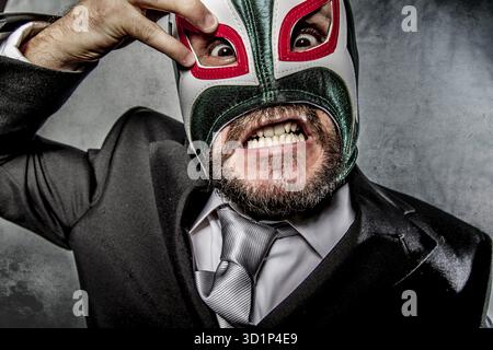 Wütender Geschäftsmann mit mexikanischer Wrestlermaske Stockfoto