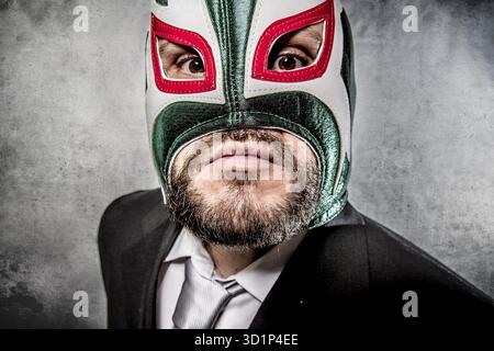 Wütender Geschäftsmann mit mexikanischer Wrestlermaske Stockfoto