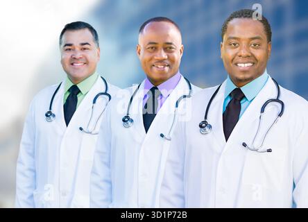 Afroamerikanische und hispanische männliche Ärzte vor dem Krankenhausgebäude Stockfoto