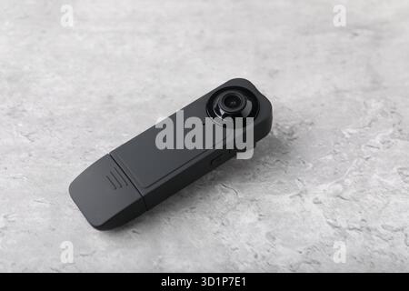 Moderne, versteckte Spionageskamera auf hellgrauem Tisch, Nahaufnahme Stockfoto
