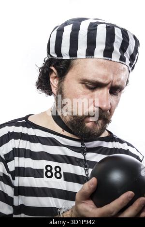 Strafe, ein kaukasischer Mann Gefangene Verbrecher mit Kette Kugel und Handschellen im Studio isoliert auf weißem Hintergrund Stockfoto