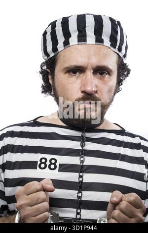 Gewalt, ein kaukasischer Mann Gefangene Verbrecher mit Kette Kugel und Handschellen im Studio isoliert auf weißem Hintergrund Stockfoto