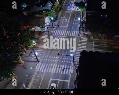 Nächtliche Luftaufnahme einer beleuchteten Kreuzung mit Straßenübergängen und leeren Straßen in Tiflis, Georgien. Stockfoto