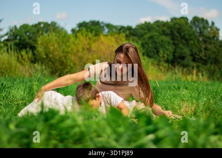 Mom und ihr Junge verbringen Zeit zusammen mit der Natur und lesen interessante Bücher über Dinosaurier. Qualitätszeit mit Kind. Stockfoto
