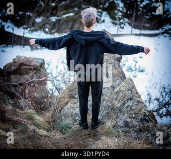 Junger Mann auf Klippe Stockfoto