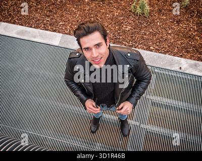 Junger Mann auf Metallgitter bei Camera suchen Stockfoto