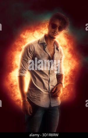 Hübscher junger Mann gegen flame Burst stehen Stockfoto